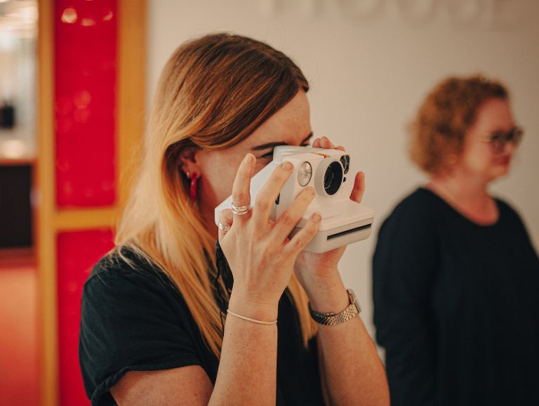 Woman taking a photo with a polaroid camera