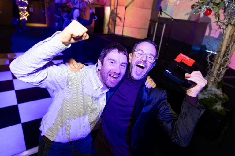 2 men celebrating their BIMA award, plunching the air whilst on the dance floor