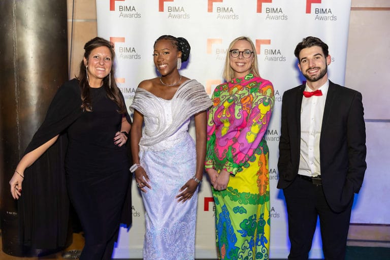 Glamorously dressed group of 4 VIPs in front of a BIMA backdrop at the BIMA awards 2024