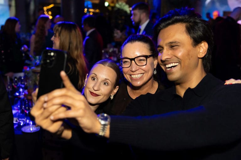 Group of 3 people taking a selfie, smiling and posing together