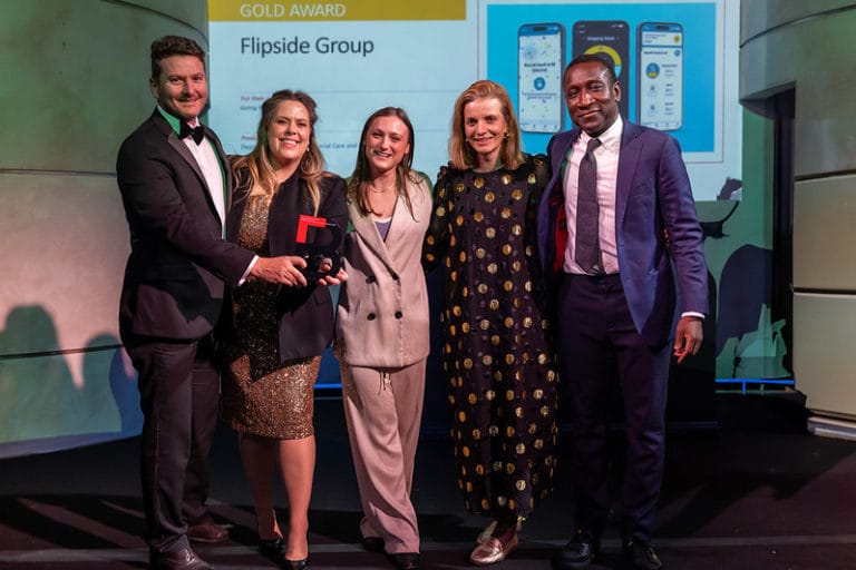 Group of 5 people proudly holding their BIMA award on stage